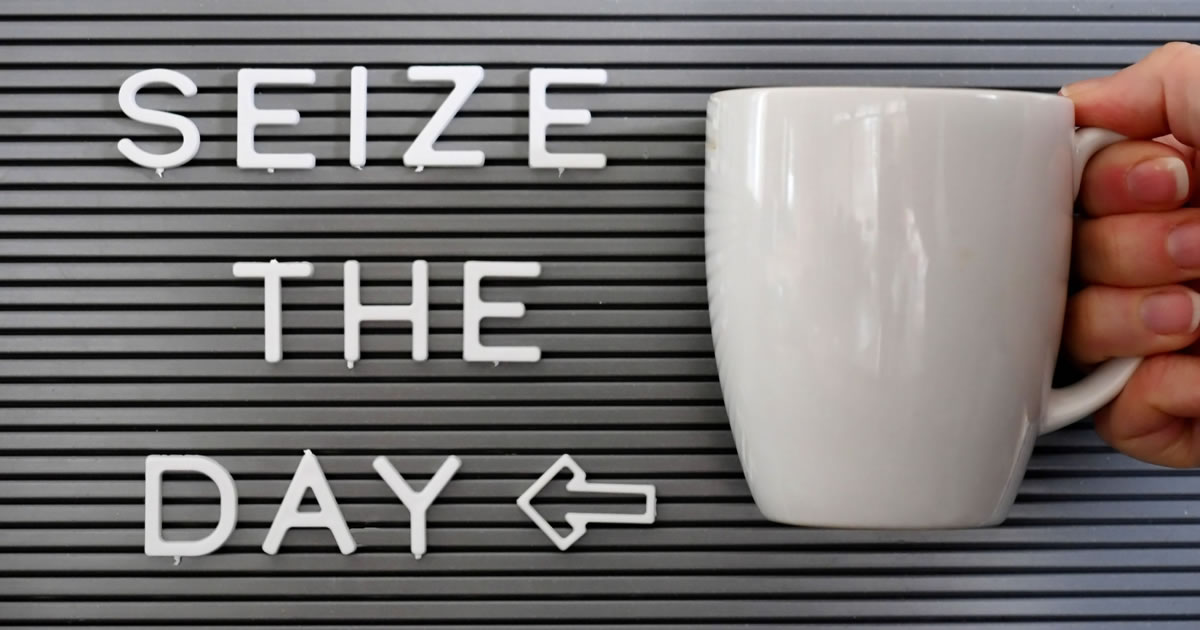 Carpe diem! A message board saying Seize the Day with a woman holding a coffee mug next to it.